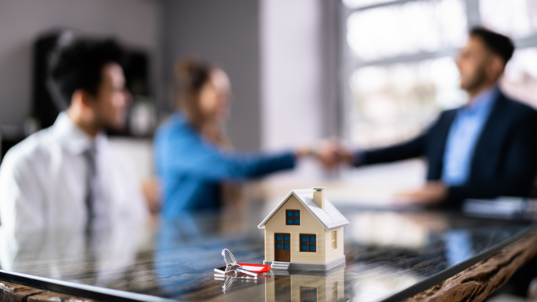 Mortgage lender meeting with clients in a modern office while discussing secure borrower verification and home loan approval.