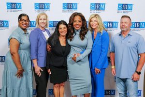 Group photo of attendees at the SHRM26 event featured in a news and important announcements section.