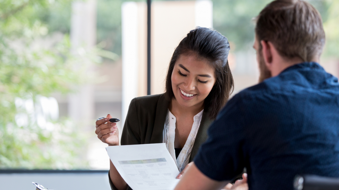 Lending professional reviewing financial documents with a borrower as part of the loan verification process.